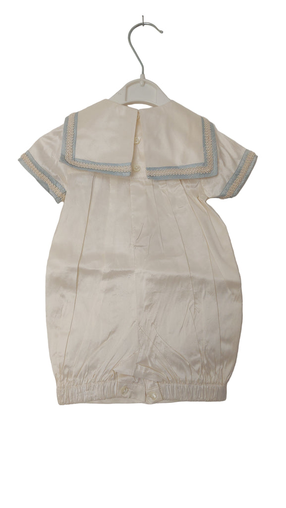 Beige outfit with blue trim on a white background