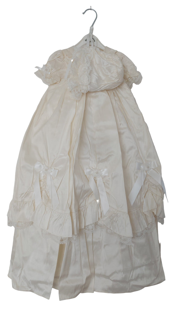 Ivory dress on a hanger against a white background